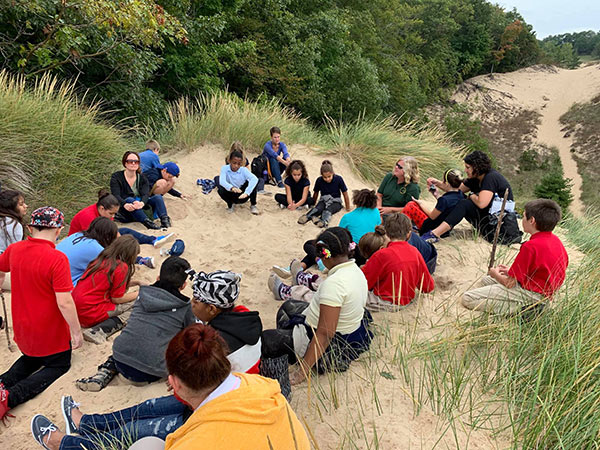 kids sitting in nature class on dunes